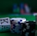 A casino scene featuring two playing cards, the ace and king of clubs, partially concealed by a player's hand. Nearby, there are stacks of multicolored poker chips on a green felt table, with blurred colorful background elements suggesting other chip stacks or cards.